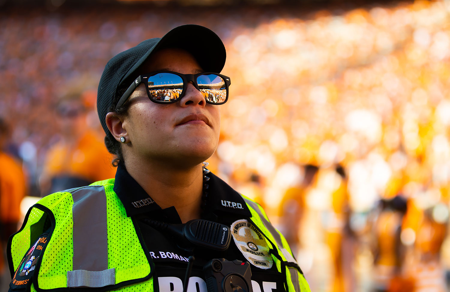 A uniformed UTPD officer stands on the sidelines during a sports event