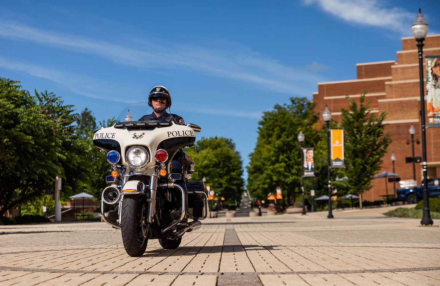 A uniformed UTPD officer sits on his UTPD motorcycle on the Pedestrian Walkway