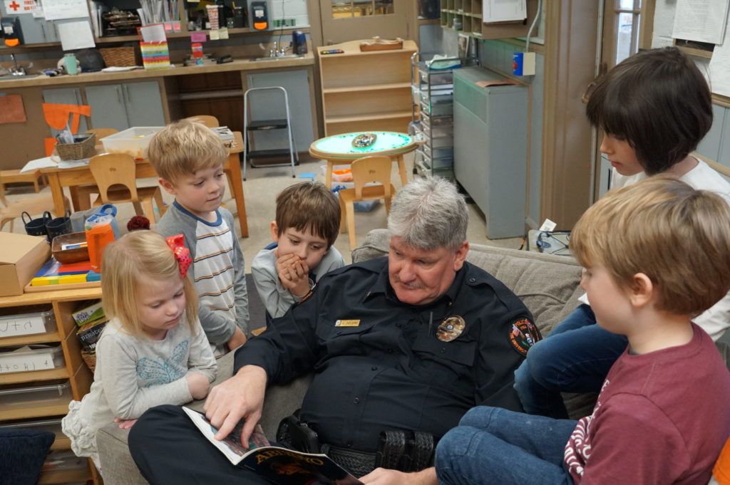 Deputy Chief Jeff Severs reads to kindergarten students at the UT Early Learning Center.