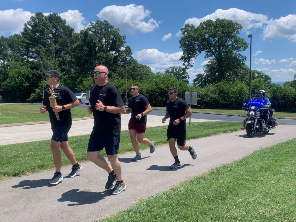 UTPD officers run in Alcoa, escorted by an Alcoa Police Department motorcycle officer.