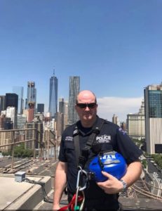 Then- NYPD Officer Sean Patterson on top of the Brooklyn Bridge. Behind him is the Freedom Tower where the twin towers once stood.